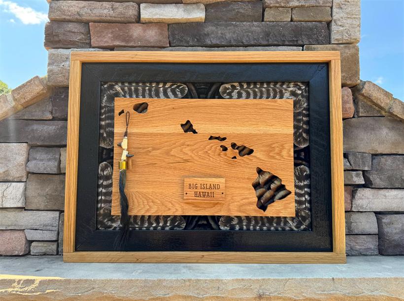 Hawaii commission — the island chain cut from oak over turkey feathers, with an engraved Big Island plaque and ebonized inner frame